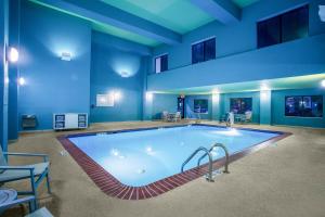 a large swimming pool in a room with blue walls at Holiday Inn Express Hotel & Suites Lewisburg by IHG in Lewisburg