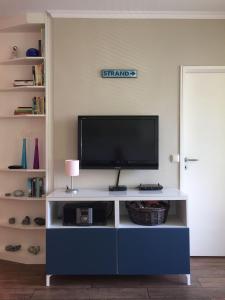 a blue and white entertainment center with a flat screen tv at 50 m zum Strand - App Strandhuepfer - Saisonstrandkorb inklusive in Timmendorfer Strand