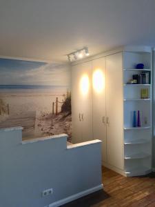 a room with a white cabinet with a beach at 50 m zum Strand - App Strandhuepfer - Saisonstrandkorb inklusive in Timmendorfer Strand