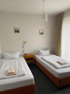 ホルン・バート・マインベルクにあるHotel Seehausのベッド2台とシャンデリアが備わる客室です。
