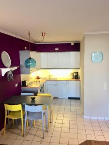 a kitchen with a table and some yellow chairs at 50 m zum Strand - App Strandhuepfer - Saisonstrandkorb inklusive in Timmendorfer Strand