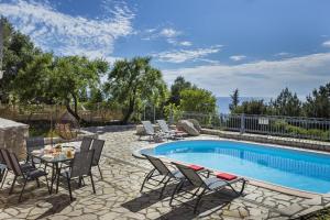 a patio with a pool and chairs and a table at Villa Fantastic View in Khalikerí