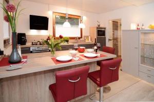 a kitchen with a table and red chairs in a kitchen at Ferienwohnung-Marion in Ennepetal