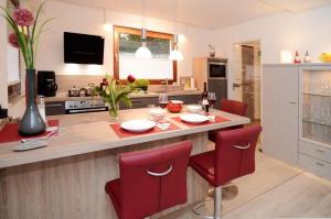 cocina con mesa y sillas rojas en Ferienwohnung-Marion, en Ennepetal