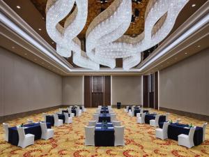 InterContinental Hangzhou, an IHG Hotel في هانغتشو: قاعة احتفالات كبيرة بها طاولات وثريا كبيرة