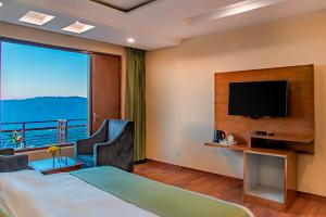 ein Hotelzimmer mit einem Bett und einem großen Fenster in der Unterkunft Vista Elite in Chail