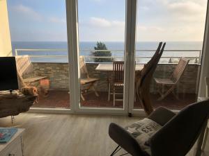 a living room with a balcony with a view of the ocean at Vier Jahreszeiten 1-58 in Großenbrode