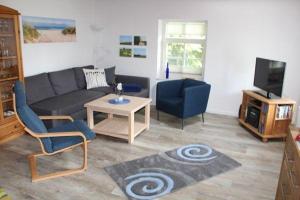 uma sala de estar com um sofá e uma mesa em Luettje-Auszeit em Dornum