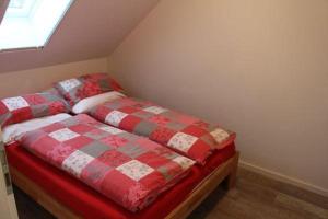 um quarto com uma cama vermelha e branca e uma janela em Luettje-Auszeit em Dornum