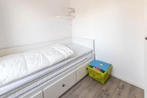 a white bed sitting in a room with a box at Ferienwohnung-in-Luebesse in Lübesse