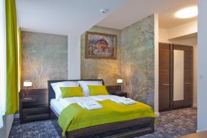 sypialnia z zielonym łóżkiem i obrazem na ścianie w obiekcie WISŁA Cechini w mieście Krynica Zdrój