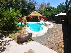 a swimming pool in a yard with a gazebo at Pumusa Bushcamp in Hluhluwe