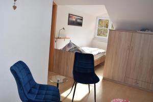1 dormitorio con 2 sillas azules y 1 cama en Haus Gauß, en Seeg