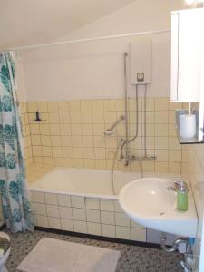 a bathroom with a bath tub and a sink at schoene-3-Zimmer-Ferienwohnung-in-St-Dionys-bei-Lueneburg in Sankt Dionys