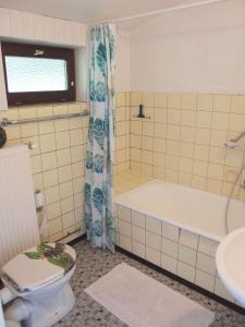 a bathroom with a tub and a toilet and a sink at schoene-3-Zimmer-Ferienwohnung-in-St-Dionys-bei-Lueneburg in Sankt Dionys