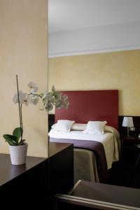 um quarto de hotel com uma cama com uma parede vermelha em Hotel Colombia em Milão