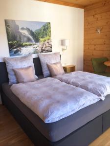 1 cama grande en un dormitorio con una pintura en la pared en Haus Annabelle, en Wagrain
