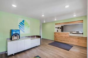 a living room with green walls and wooden floors at WoodSpring Suites Chicago Addison in Addison