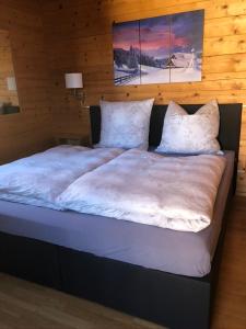 1 cama grande con sábanas y almohadas blancas en Haus Annabelle en Wagrain
