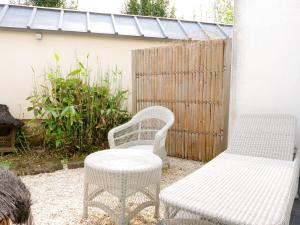 two white chairs and a bench on a patio at Villa Kerasy Hotel Spa in Vannes