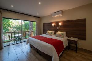um quarto com uma cama grande e uma varanda em Seasons Golf, Leisure, Spa em Hartbeespoort
