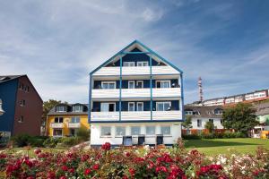 uma casa azul e branca com flores à frente em Hotel Helgoländer Klassik em Helgoland