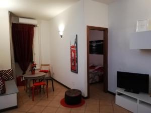 Rosso rubino في روما: غرفة معيشة مع طاولة وتلفزيون وغرفة