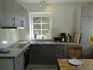 eine Küche mit Küchengeräten aus Edelstahl und einem Tisch in der Unterkunft Bispinger Heidezauber - Haus Hartriegel in Bispingen