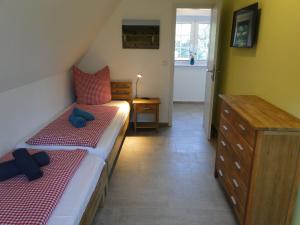 1 Schlafzimmer mit 2 Einzelbetten und einer Kommode in der Unterkunft Bispinger Heidezauber - Haus Hartriegel in Bispingen
