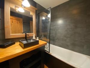 un bagno con lavandino e vasca da bagno di Appartement de Standing - ARC 1950 - 6 personnes - départ et retour à skis ad Arc 1950 Altre 41 foto