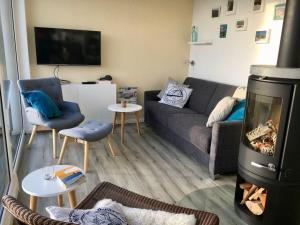 Una sala de estar con un sofá y una chimenea. en MEHS46A21-FeWo-Best-Kiekout, en Meeschendorf