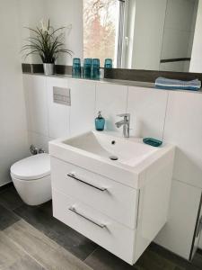 Un baño blanco con lavabo e inodoro. en MEHS46A21-FeWo-Best-Kiekout, en Meeschendorf