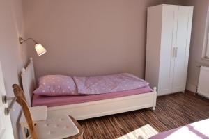 a small bedroom with a bed and a cabinet at Bungalow-Gartenzauber in Grube