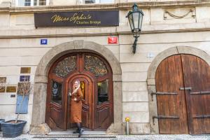 a woman standing in front of a building with two doors at Miss Sophie's Charles Bridge in Prague