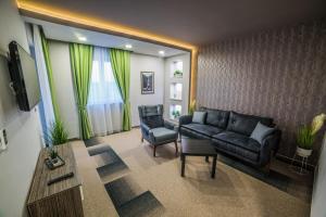 uma sala de estar com um sofá preto e uma cadeira em Hotel River em Bijeljina