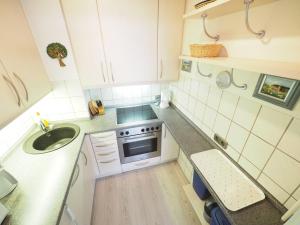 uma pequena cozinha com um lavatório e um fogão em Appartement-167 em Westerland