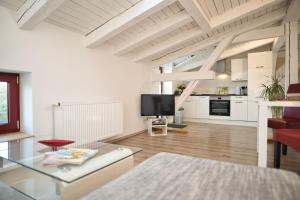 a living room with a glass table and a kitchen at Haus Steuerrad in Stralsund