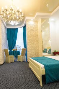 Habitación con cama, mesa y lámpara de araña. en Arkadia apartment with sea view, en Odessa