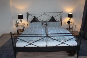 1 dormitorio con cama negra con sábanas y almohadas azules en Ferienwohnung-Villa-Helene, en Blankenburg