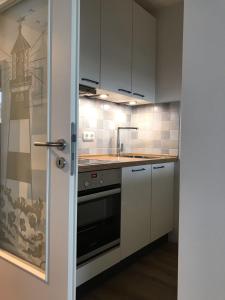 a kitchen with white cabinets and a stove at Beachhouse-Staberdorf in Staberdorf