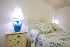 a bedroom with a bed with a blue lamp on a night stand at Agriturismo Arco di Sole in Alberobello