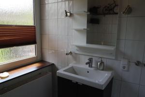 a bathroom with a sink and a mirror at Luettje-Glueck-2 in Pogum