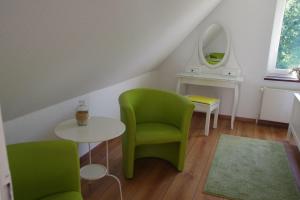 a room with green chairs and a table and a mirror at Luettje-Glueck-2 in Pogum