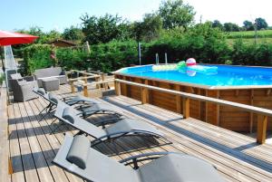 eine Terrasse mit Stühlen und einem Pool in der Unterkunft Rural spacious bungalow with pool in Chalandrey