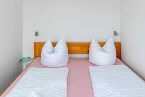 - 2 lits avec des oreillers blancs dans une chambre dans l'établissement Ferienwohnung Oberdeck, à Schilksee