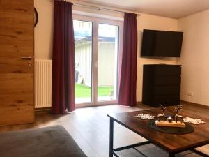 Una sala de estar con una mesa y una gran ventana. en Appartement Schneekristall, en Westendorf