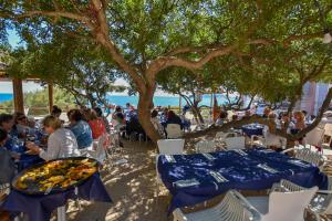 a group of people sitting at tables under a tree at Villa La Buena Vida in Benissa