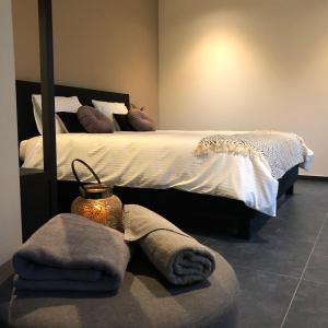 een slaapkamer met een bed en handdoeken op de vloer bij Huis Berenbroek in Genk