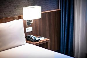 
a hotel room with a bed and a lamp at Holiday Inn Express Rotterdam - Central Station, an IHG Hotel in Rotterdam
