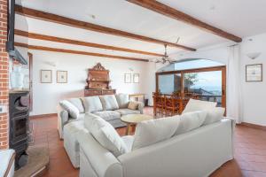 un soggiorno con divani bianchi e tavolo di Casa Vista mare Bosa/Magomadas a Magomadas